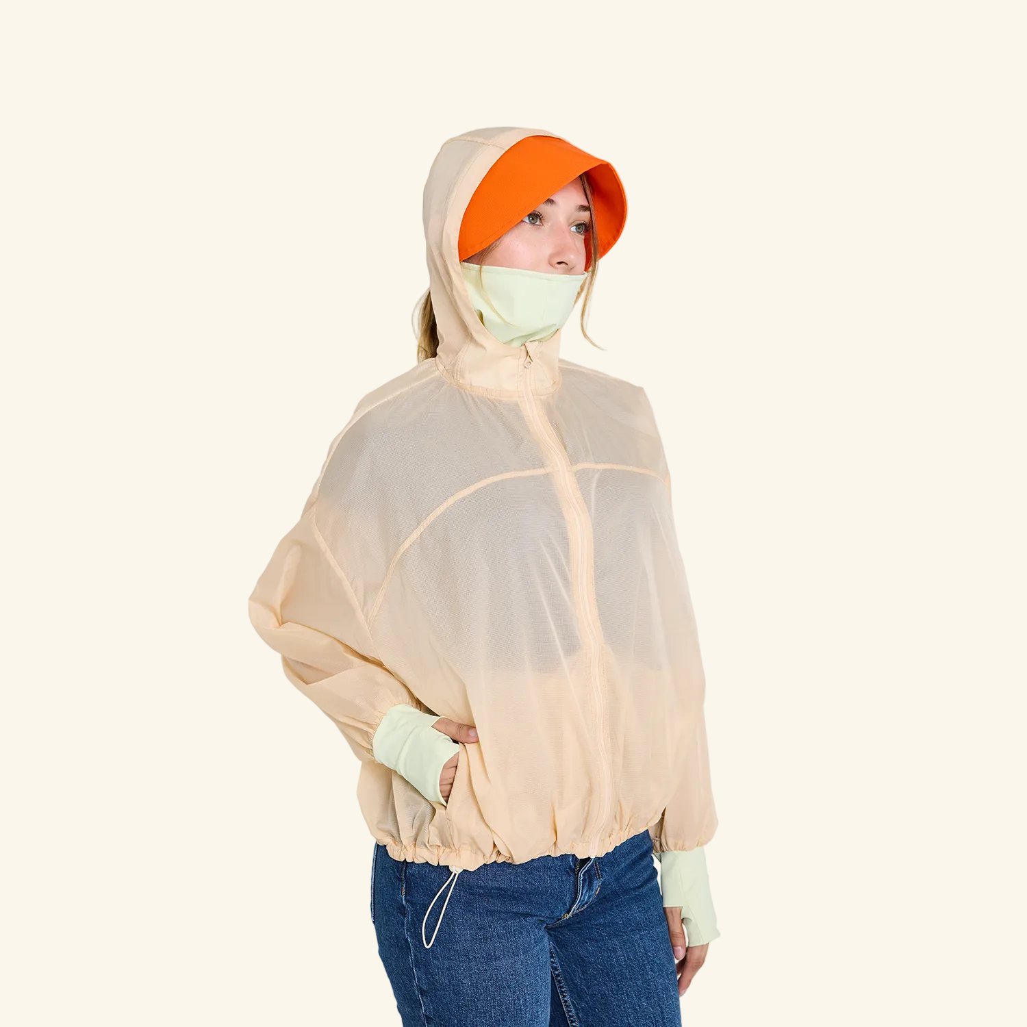 CJW Sun Jacket in cream— lightweight nylon jacket with removable brim and face mask, worn by model