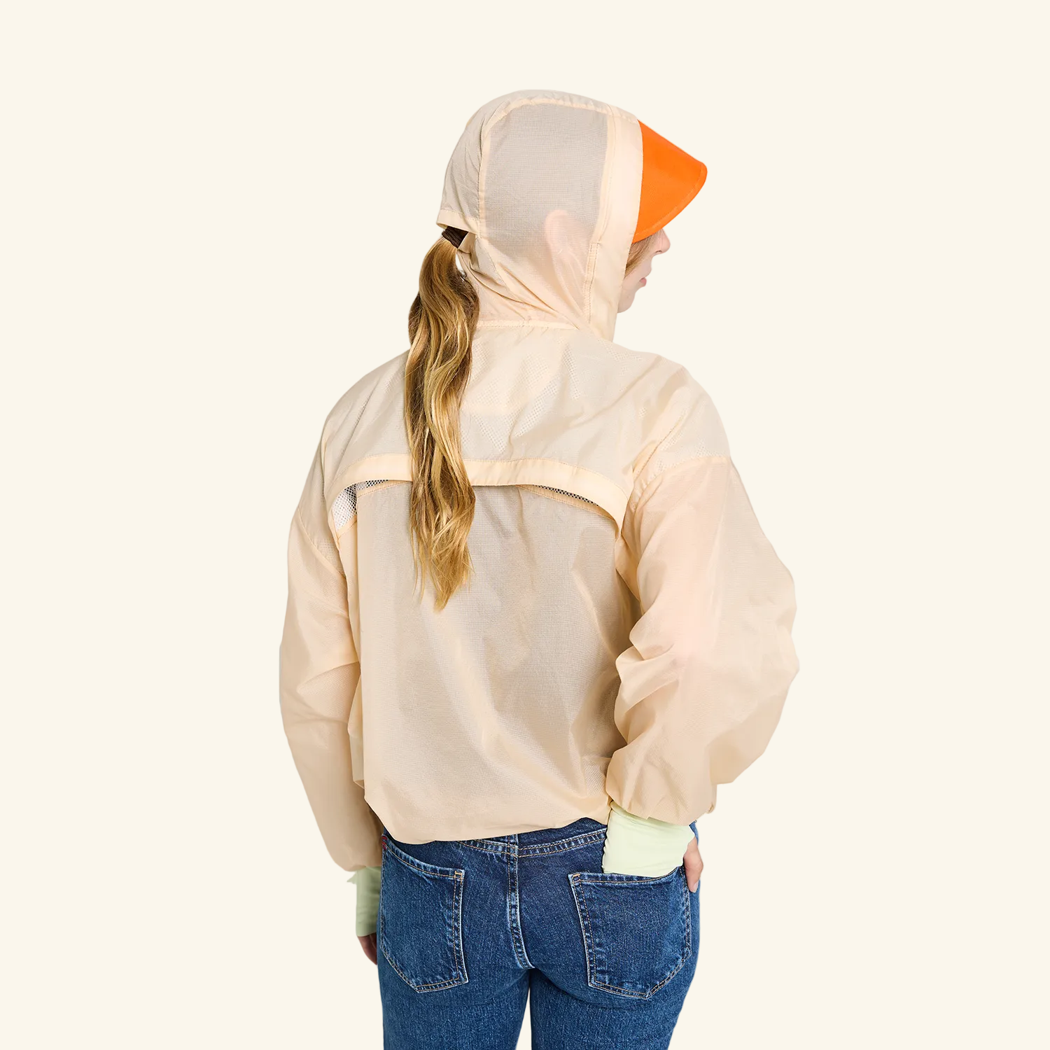 CJW Sun Jacket in cream— lightweight nylon jacket with removable brim and face mask, worn by model. back view