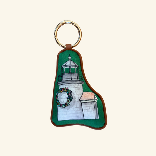 leather trimmed green bag charm of light house decorated with a holiday wreath